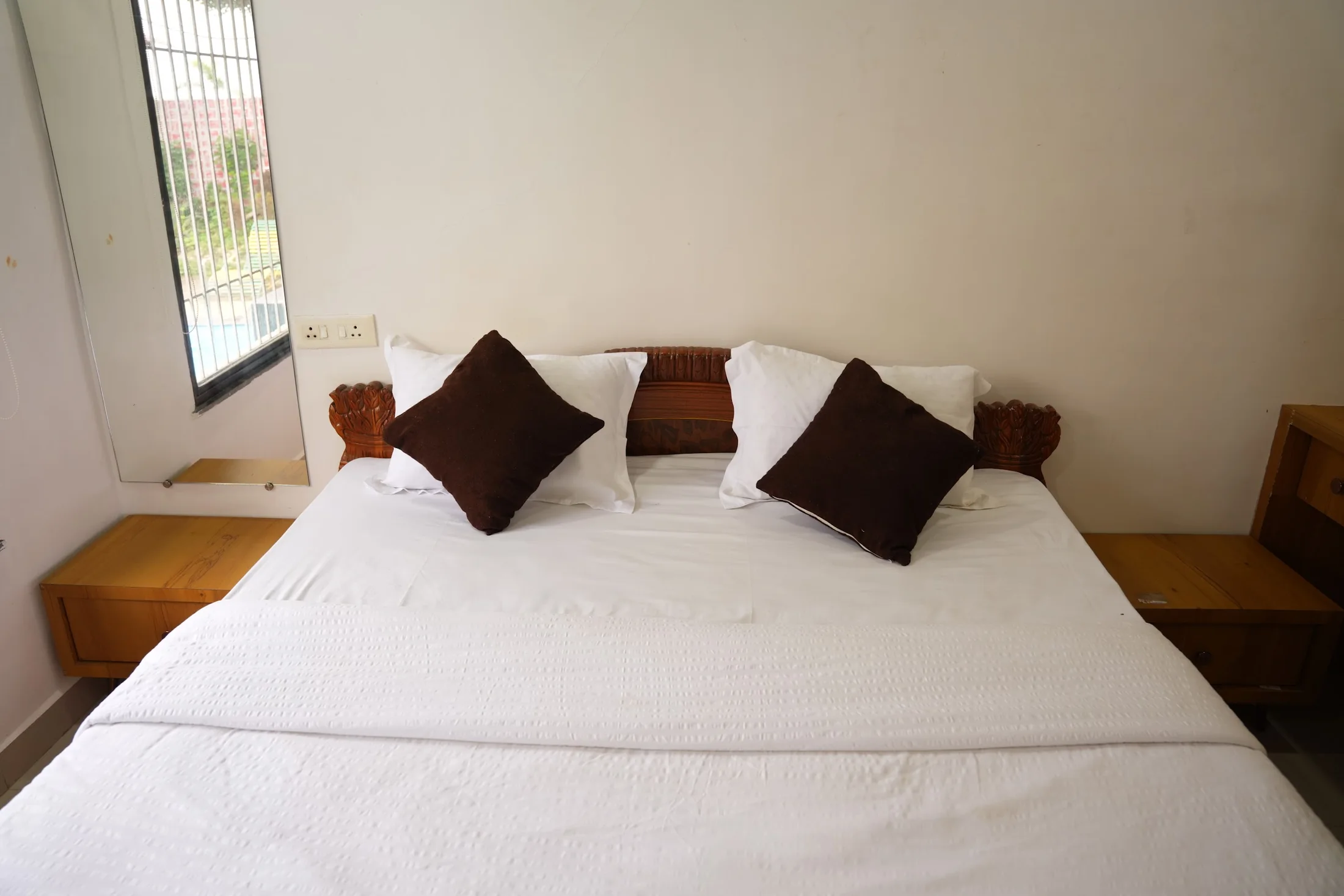 Bungalow king bedroom at DS Agro Tourism & Resort. A bright private bedroom inside the DS Bungalow.