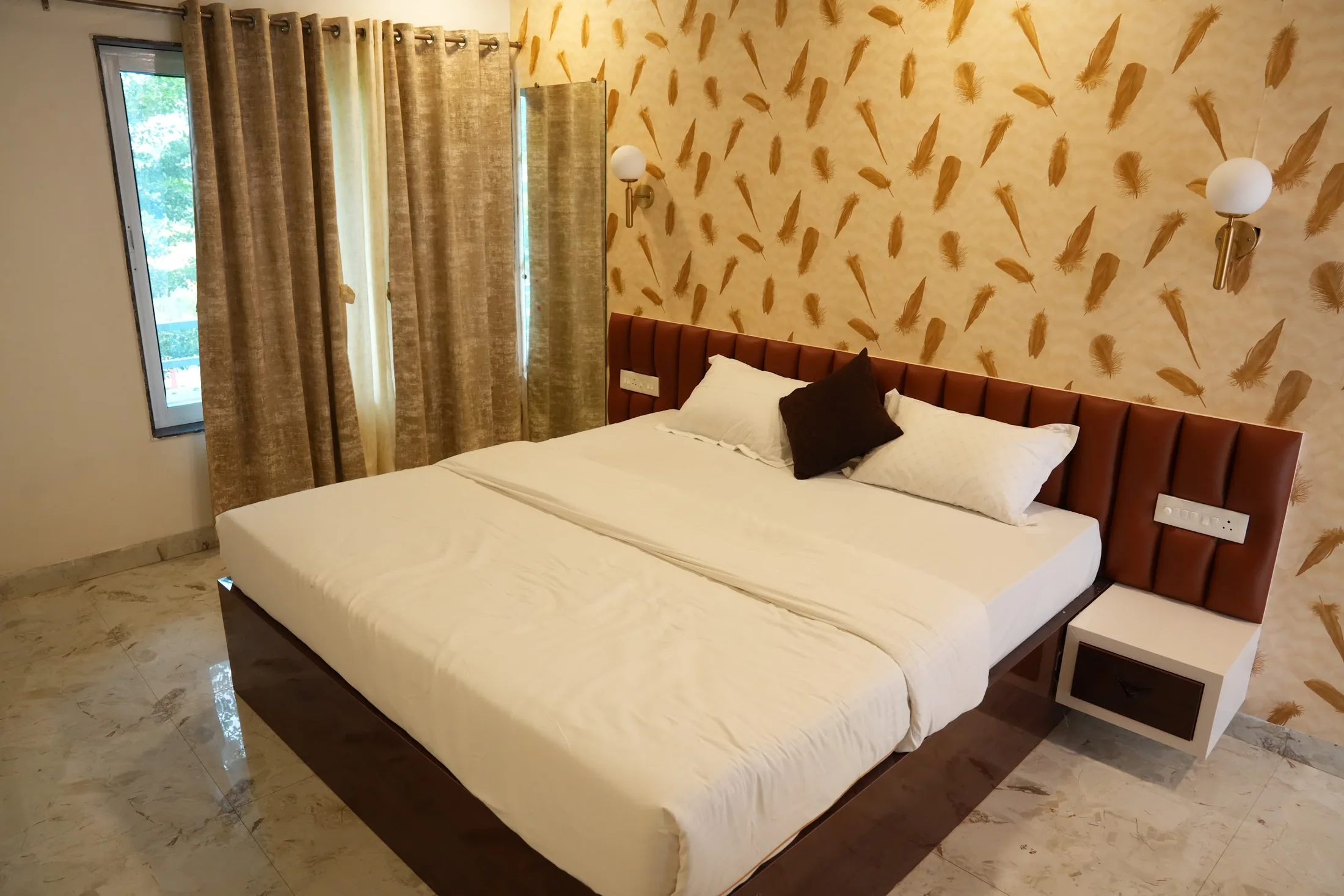 Deluxe room by the window at DS Agro Tourism & Resort. Natural light across a second Deluxe room interior.