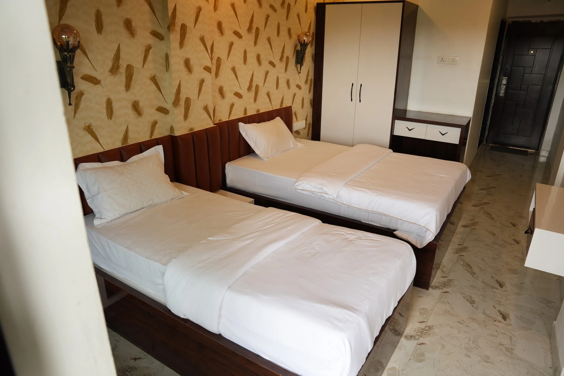 Deluxe twin room entry at DS Agro Tourism & Resort. A twin-bed room with storage and entrance in view.