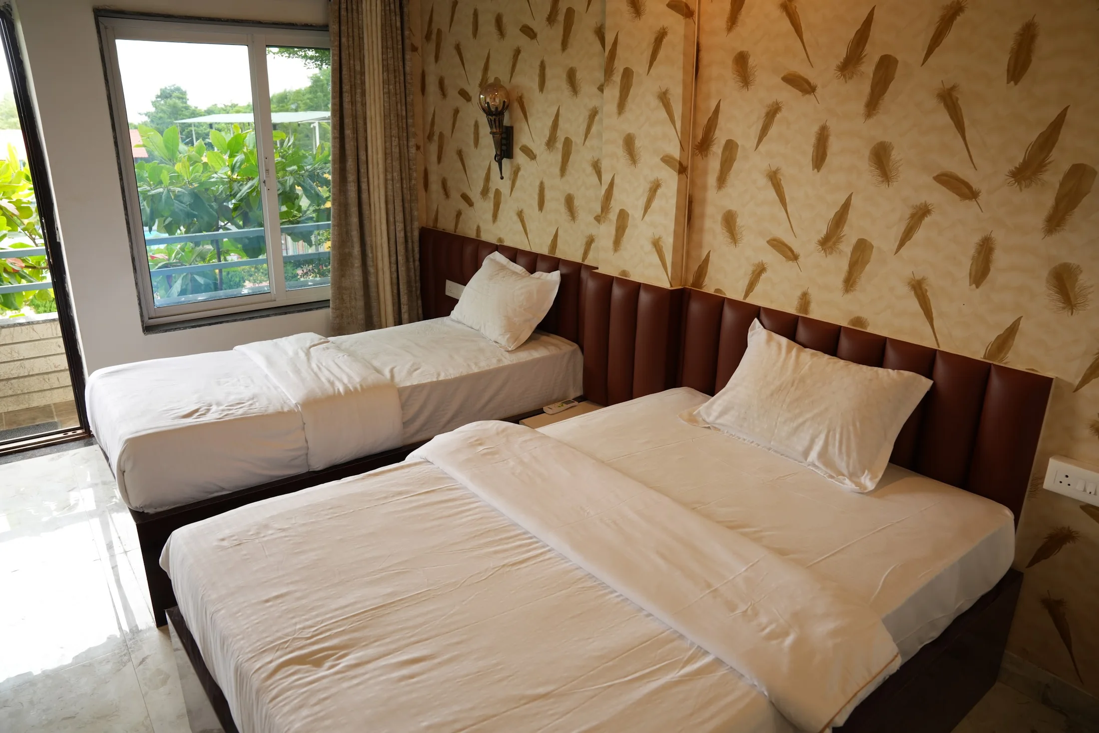 Deluxe twin room window at DS Agro Tourism & Resort. A second twin-bed layout beside the garden-facing window.