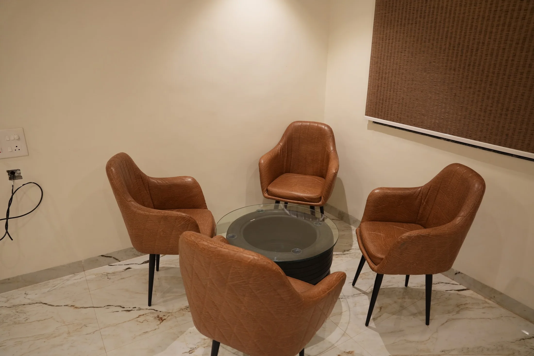 Premium seating at DS Agro Tourism & Resort. Armchairs around a small round table inside the room.