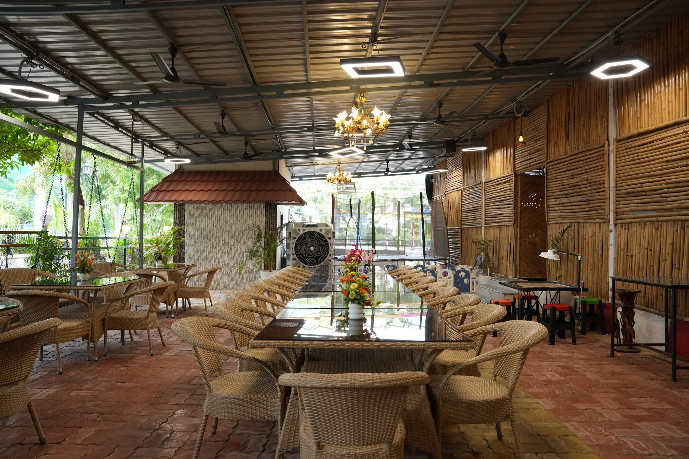 Resort restaurant at DS Agro Tourism & Resort. The open-sided dining space with long tables and garden views.