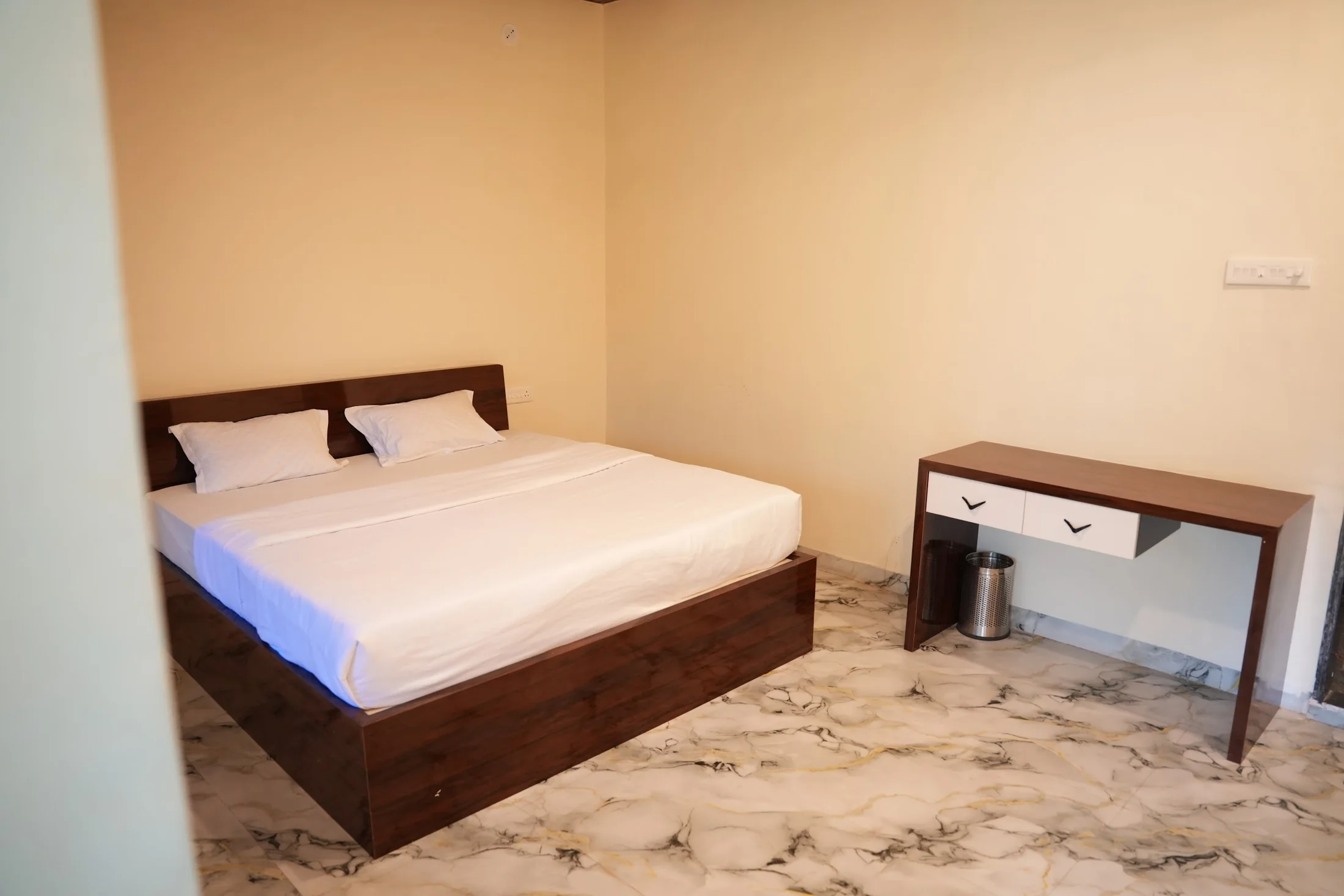 Super Deluxe bedroom at DS Agro Tourism & Resort. The bed and writing desk in the verified Super Deluxe room.