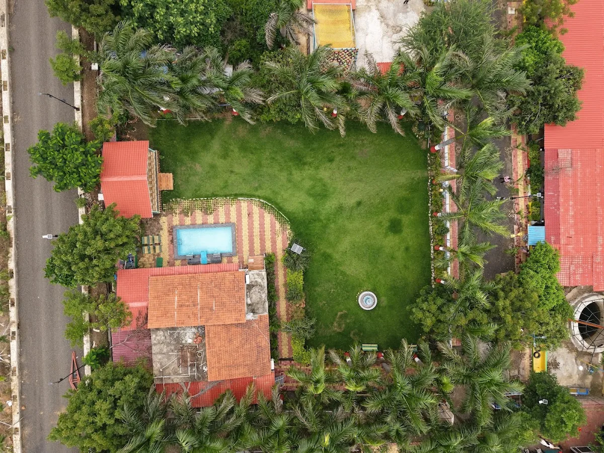 Pool and lawn at DS Agro Tourism & Resort. Open green space next to the pool and stay areas.