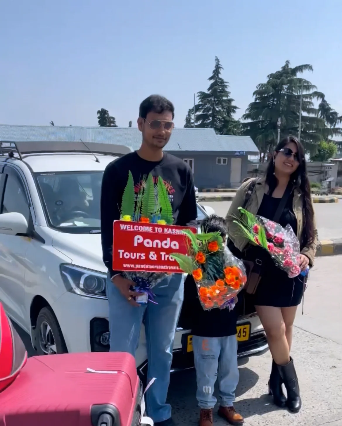 A family holding flowers during their Kashmir airport welcome