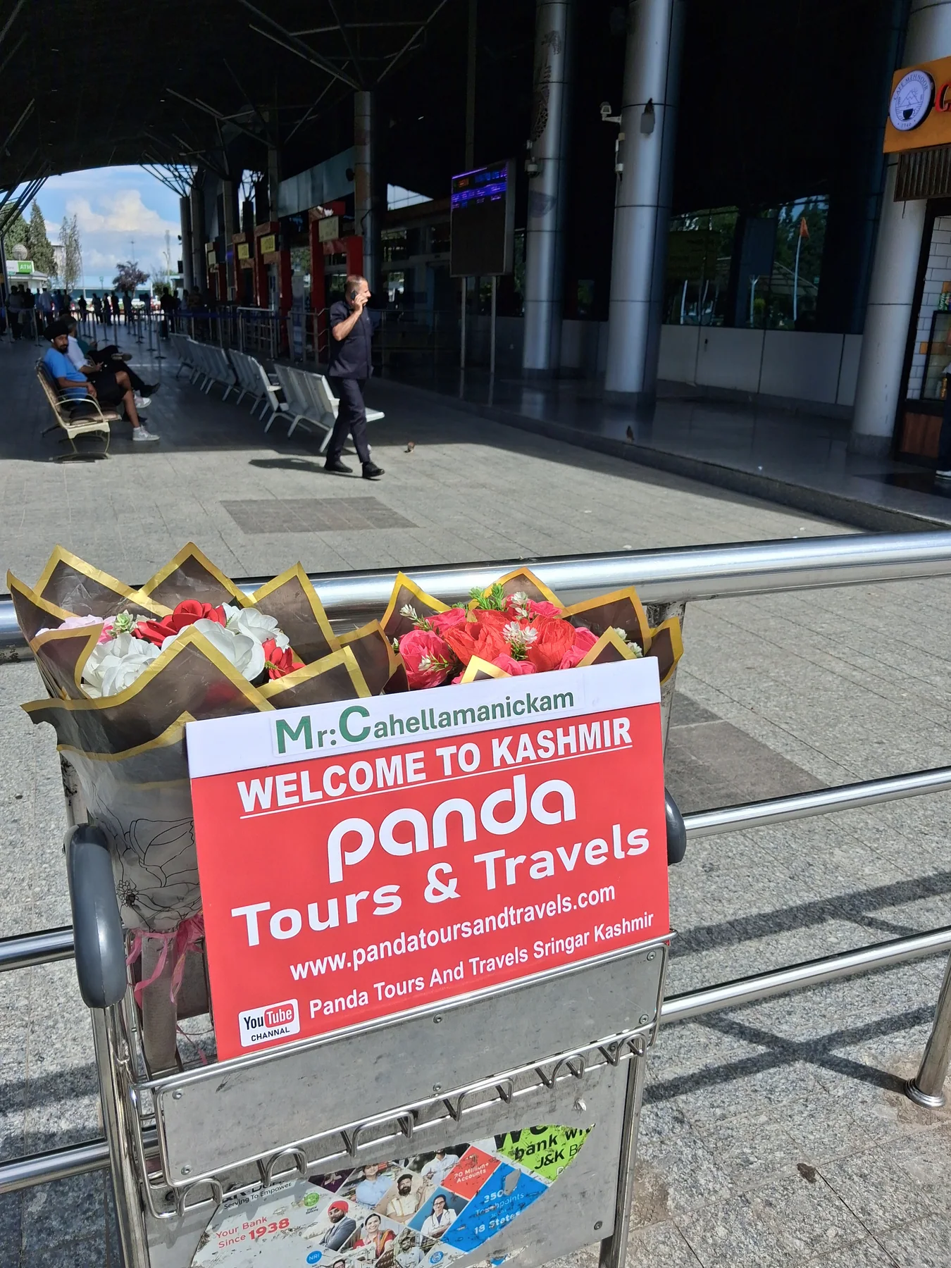 Fresh flower bouquets and a Panda Tours welcome sign at Srinagar airport