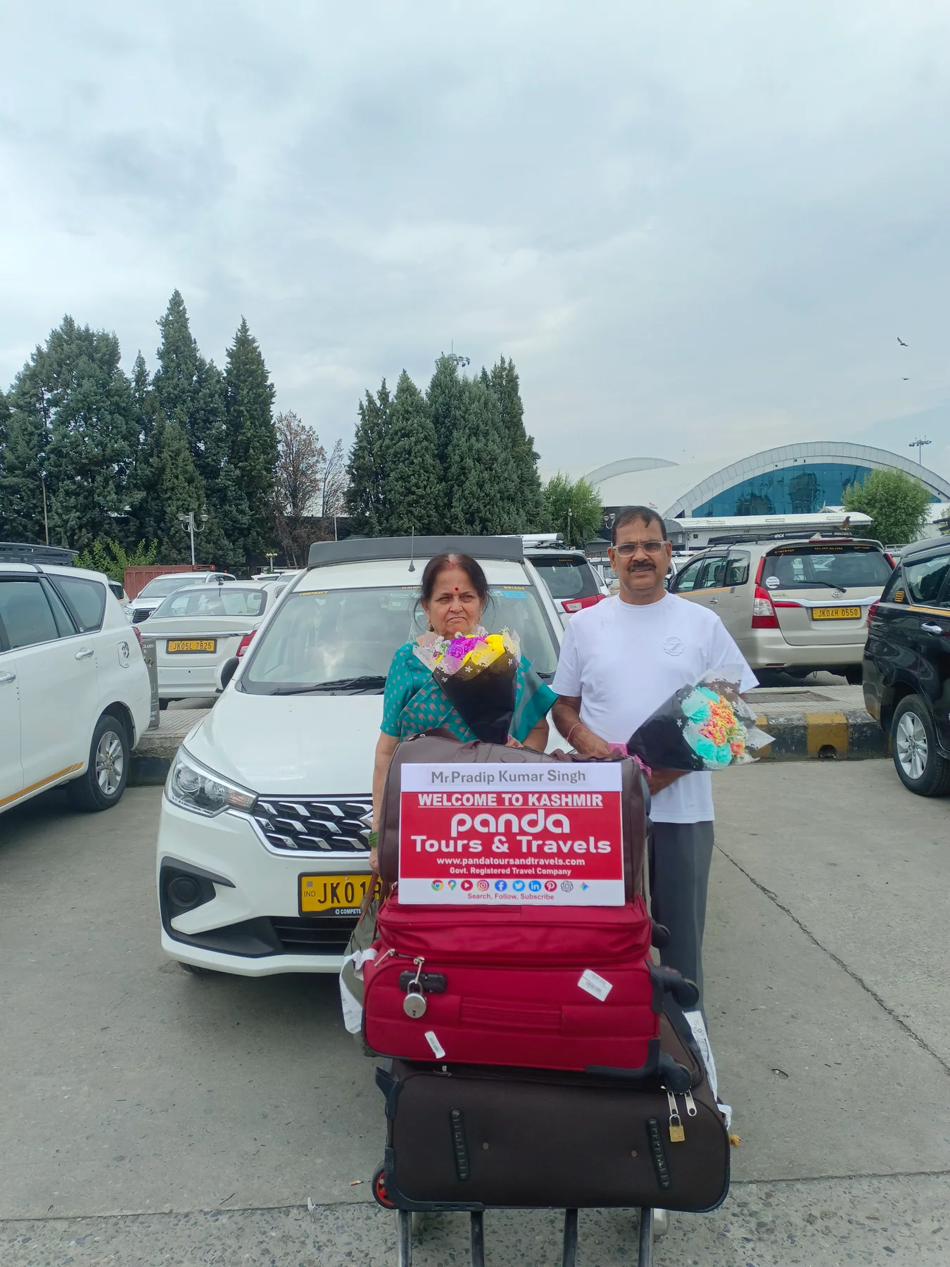 A senior couple welcomed beside their private car at Srinagar airport